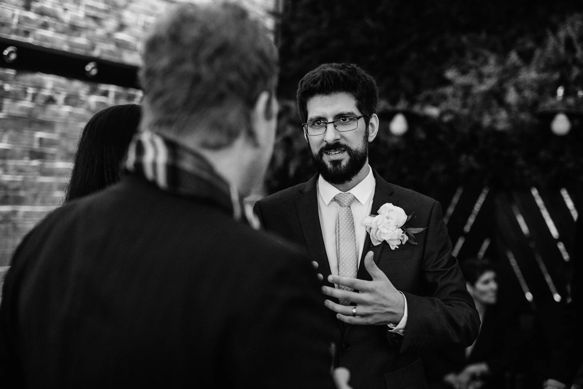  The groom speaks to a wedding guest 