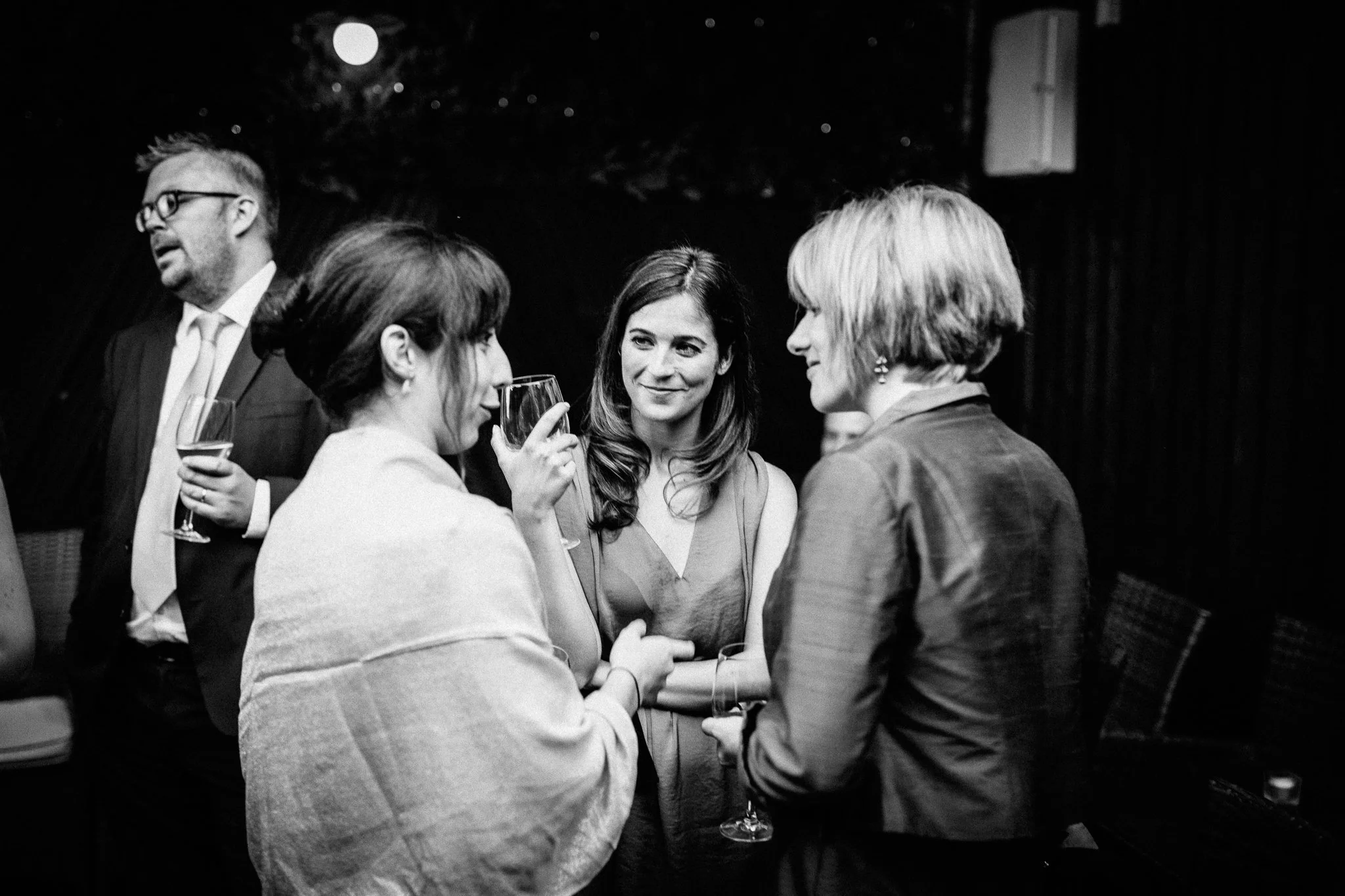  Wedding guests talk in a huddle 