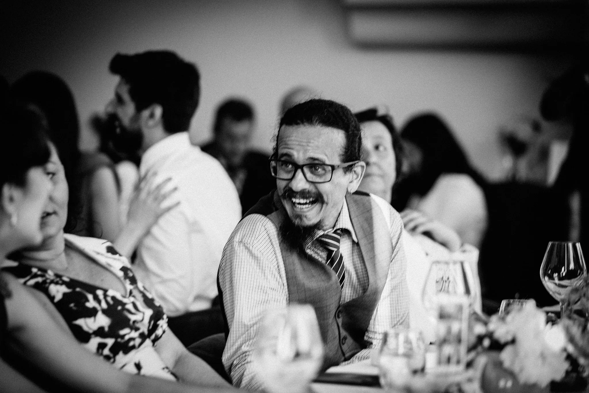  Wedding guests laughs whilst seated 