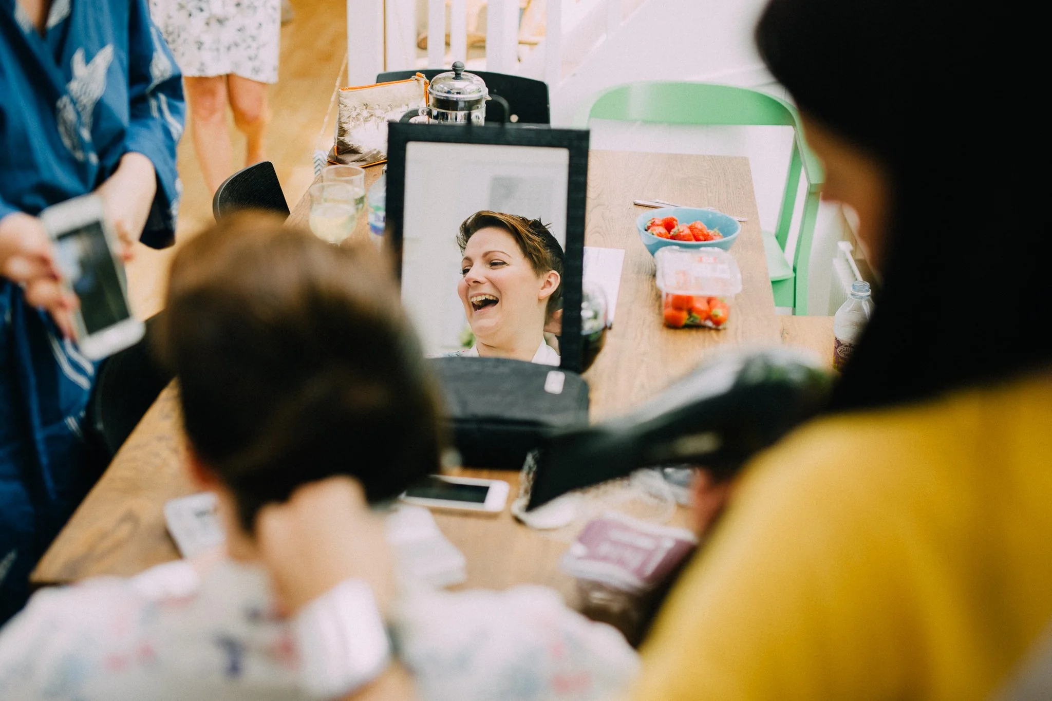  Bride laughing with her reflection in a mirror 