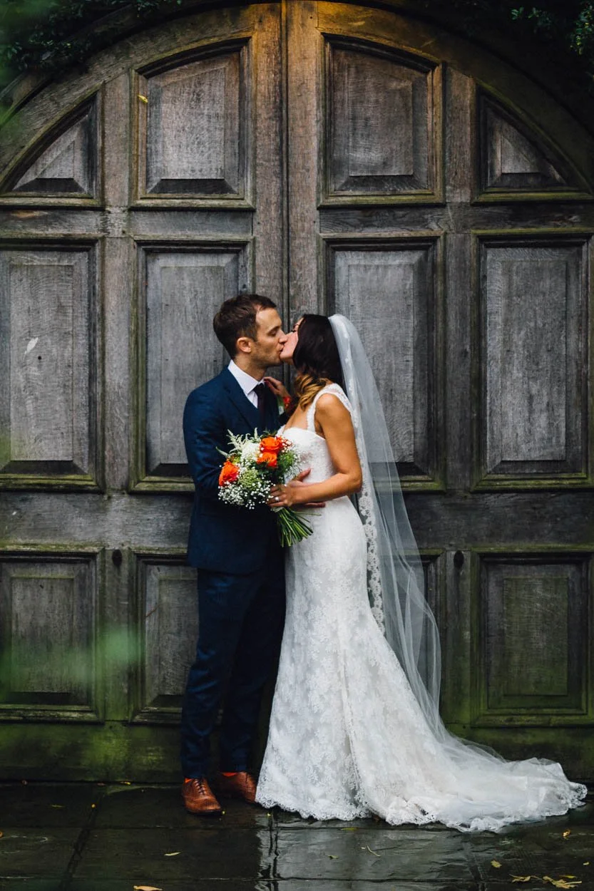 bride and groom kissing in church doorway