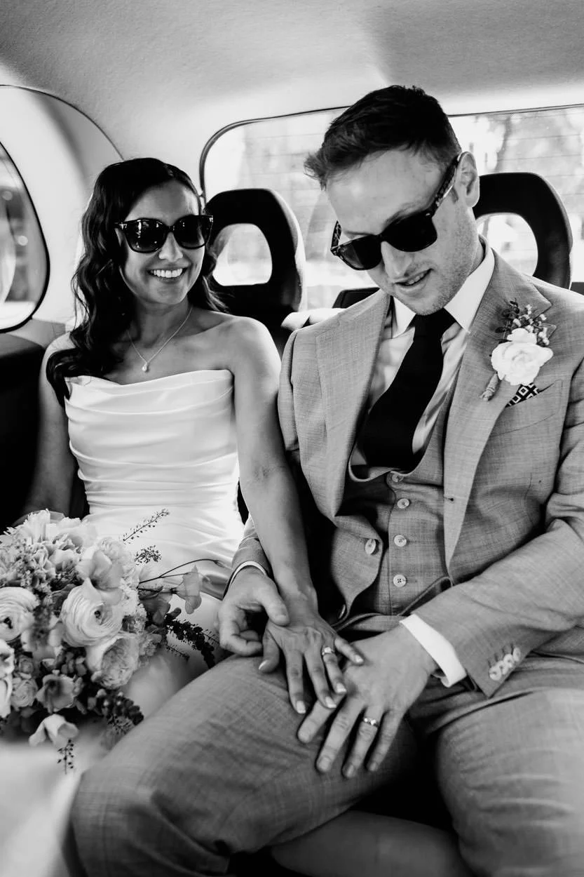 black and white image of bride and groom in taxi