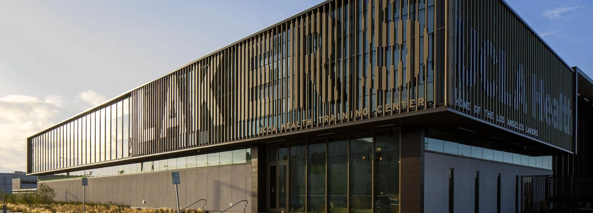 The UCLA Health Training Center, a modern building with a facade of vertical metal slats and large glass windows, located in Los Angeles.