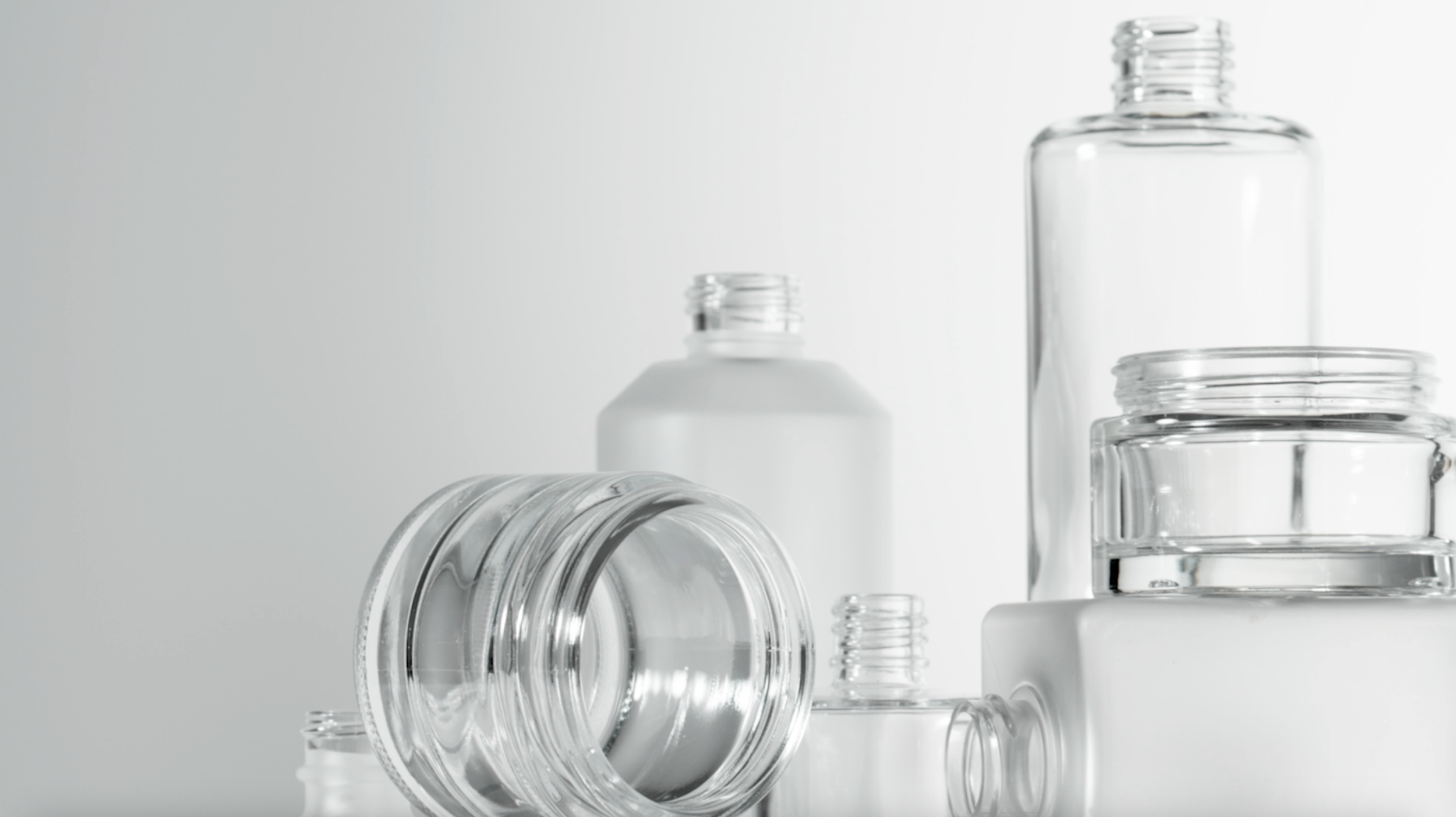 image of various, clean and empty skincare vials stacked in an aesthetically pleasing way.
