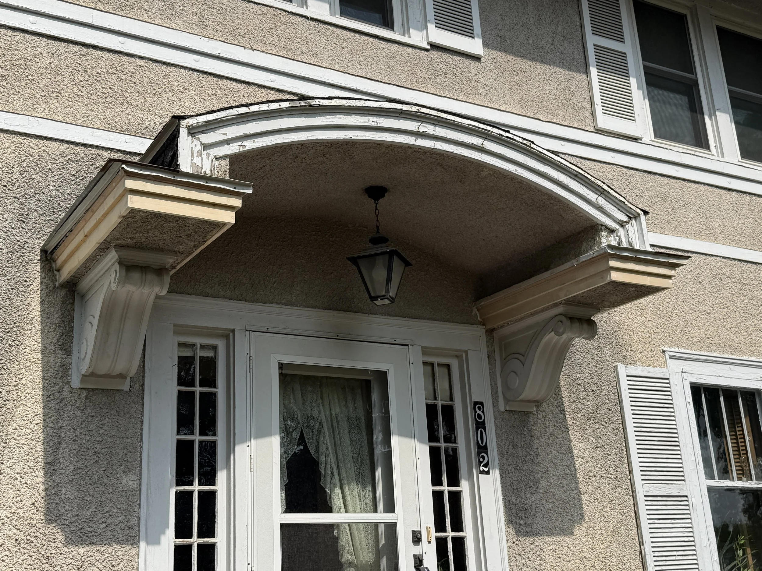 Close-up of  house's exterior above the front door that was fixed by DS Home Solutions; the house exterior is beige with a textured finish..