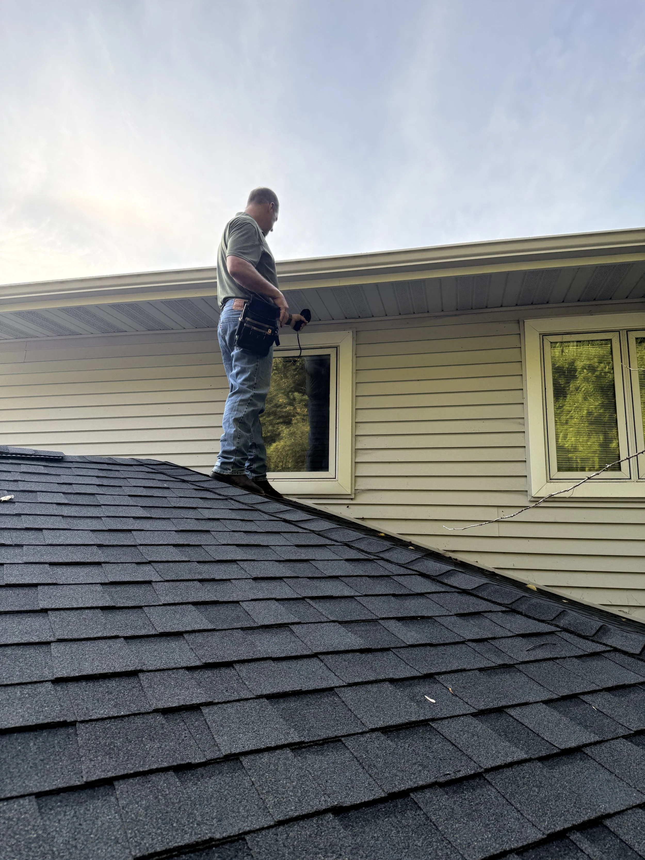 Daryl Trautmiller inspecting a home on the roof
