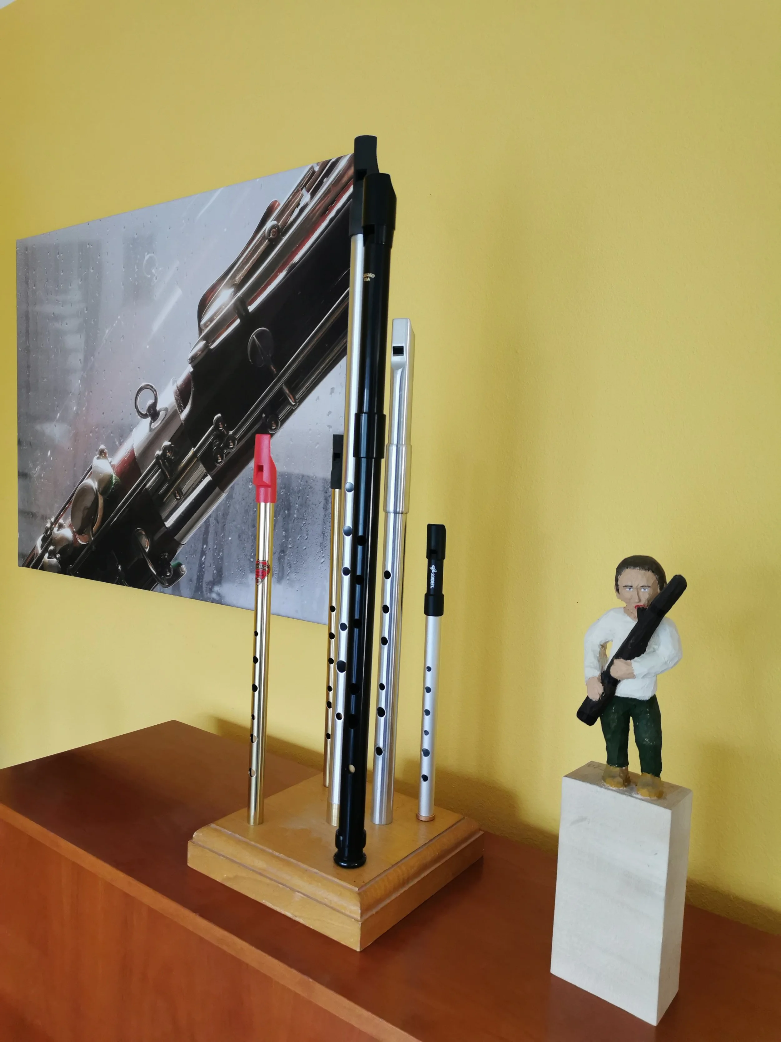 Whistles und eine Holzfigur, die ein Fagott spielt, stehen auf einem Klavier.