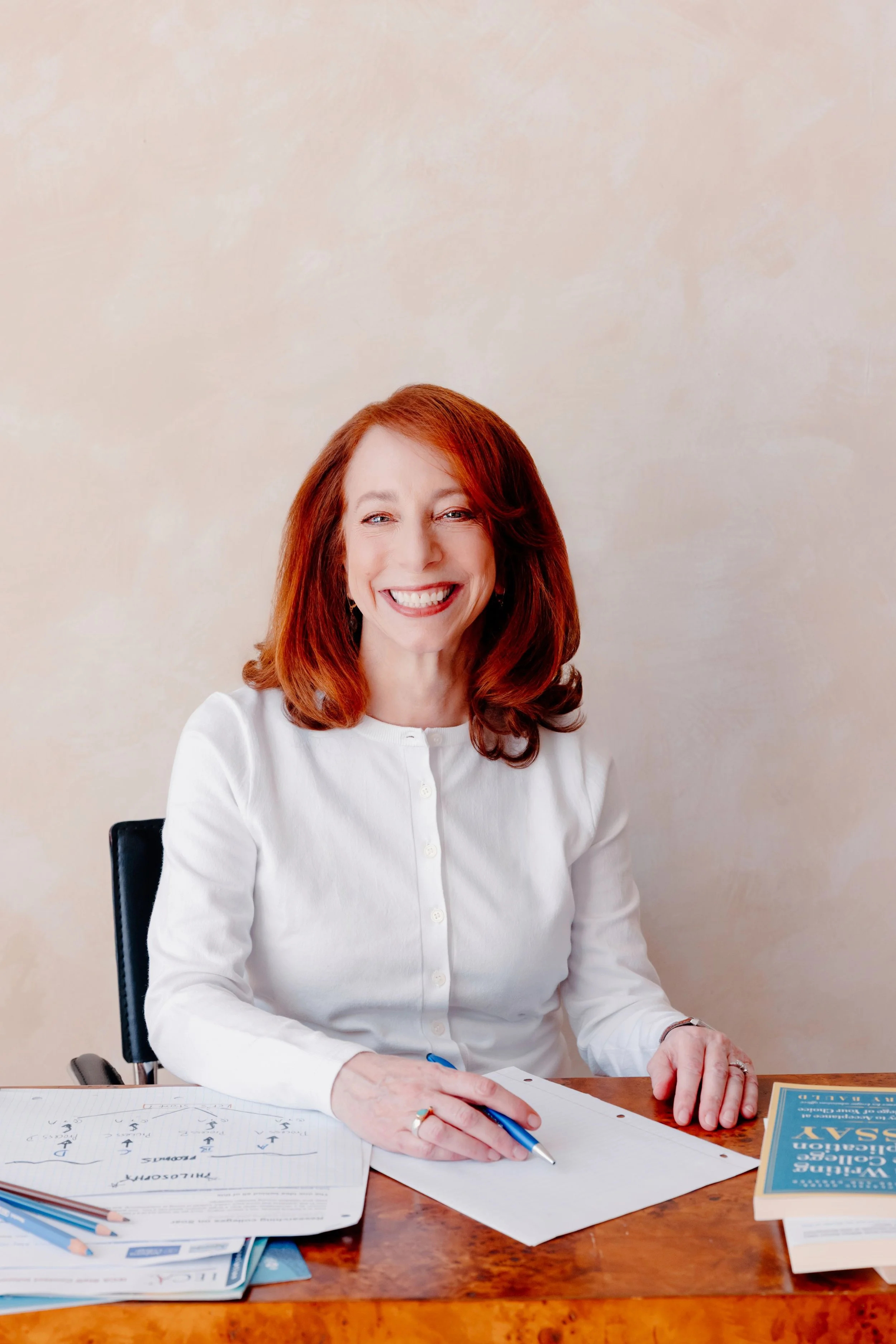 College admissions counselor Barbara Rifkind sitting at a table and smiling-drop-shadow