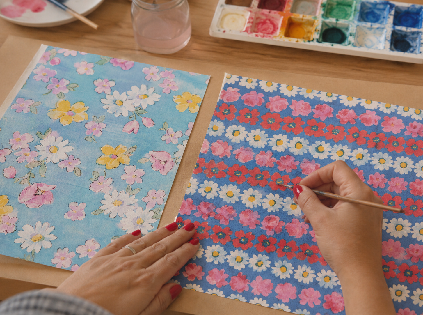 Une personne peignant un motif floral coloré sur un papier, avec une palette de peinture à côté.