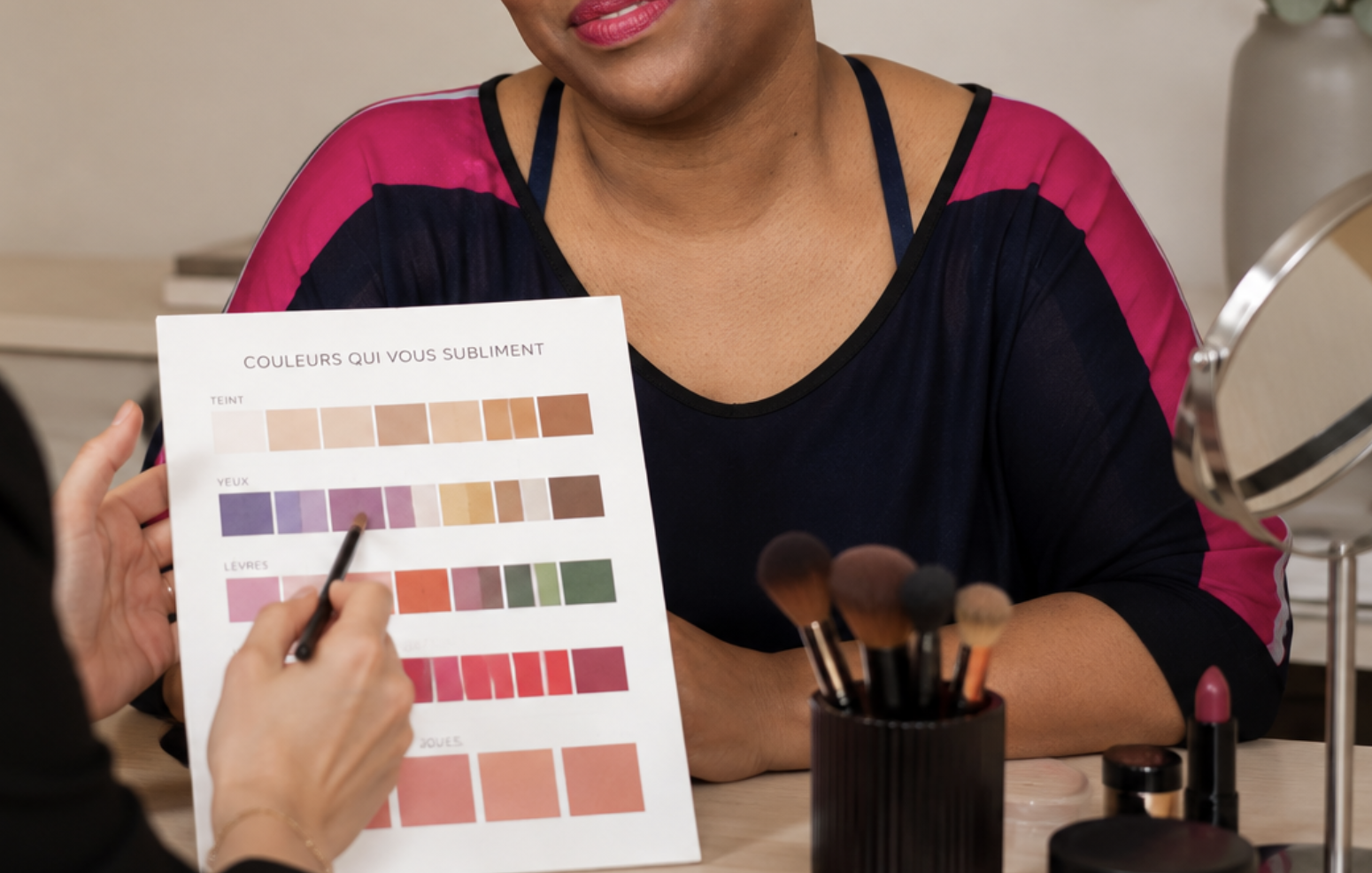Une femme montre une brochure sur les couleurs qui la mettent en valeur, y compris des nuances de teint, de yeux, de lèvres et de joues, dans un salon de beauté ou de maquillage.