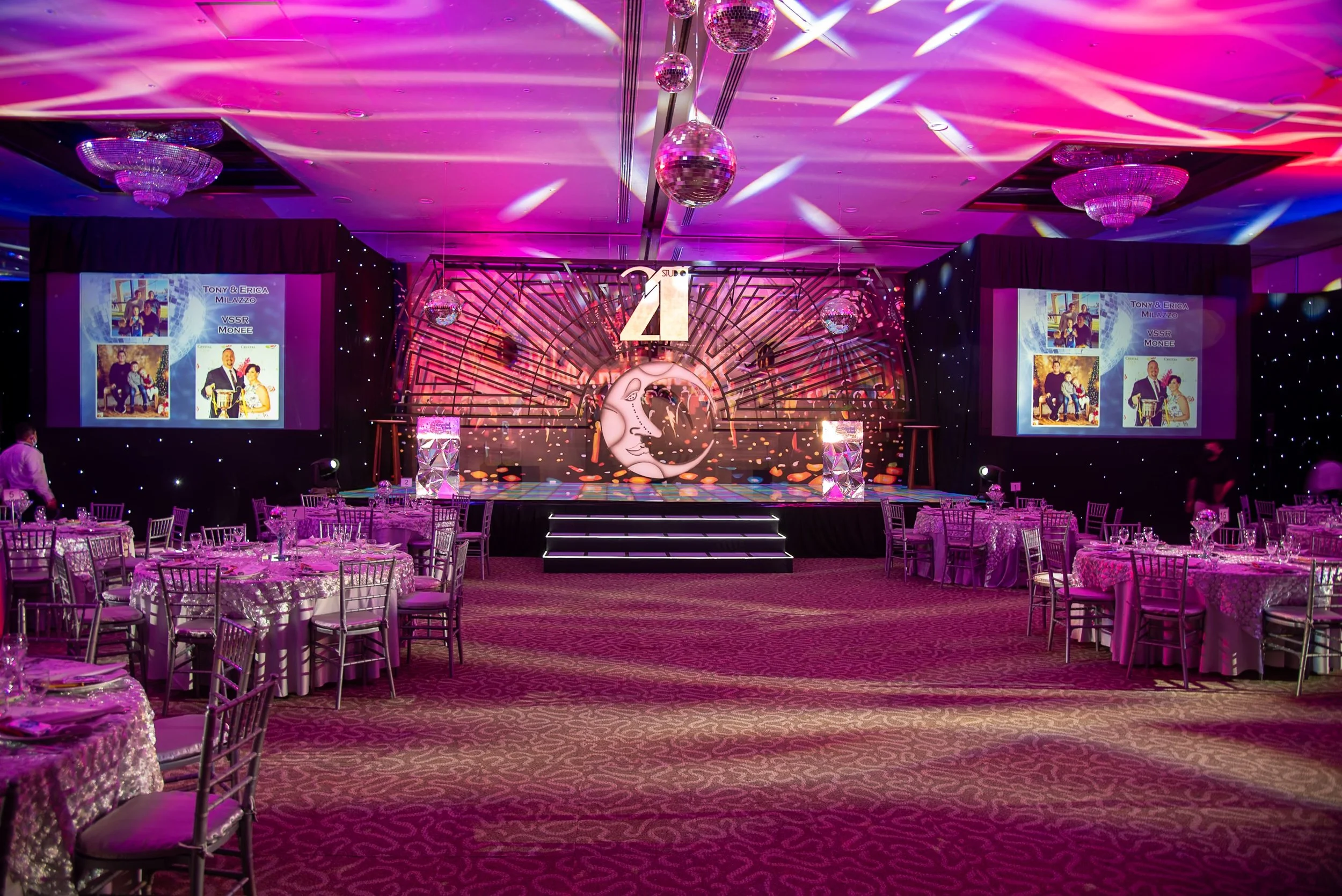 Elegant corporate event venue with stage, projection screens and professional event lighting