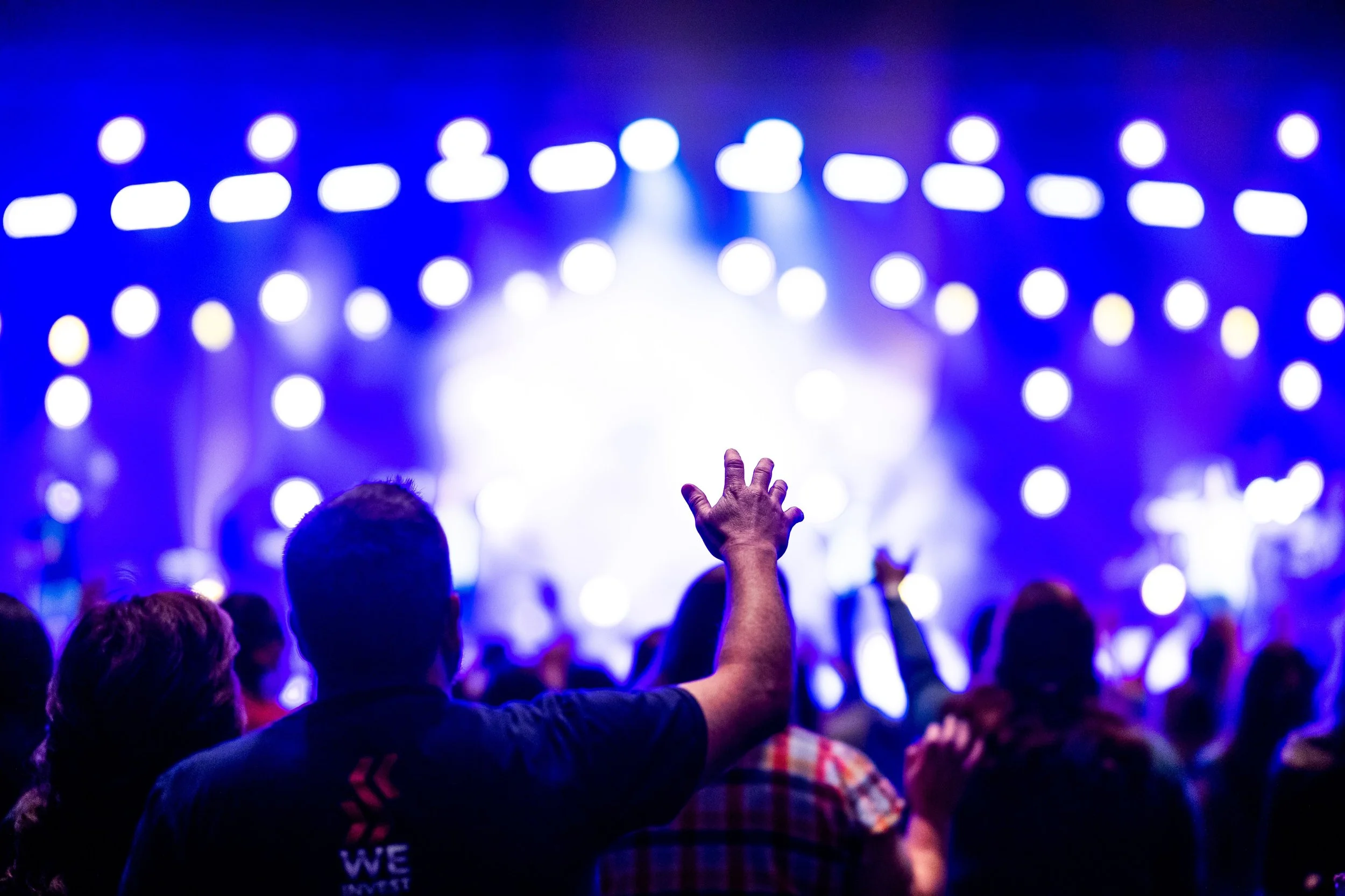 Live music festival crowd enjoying a concert with stage lighting and high-energy entertainment