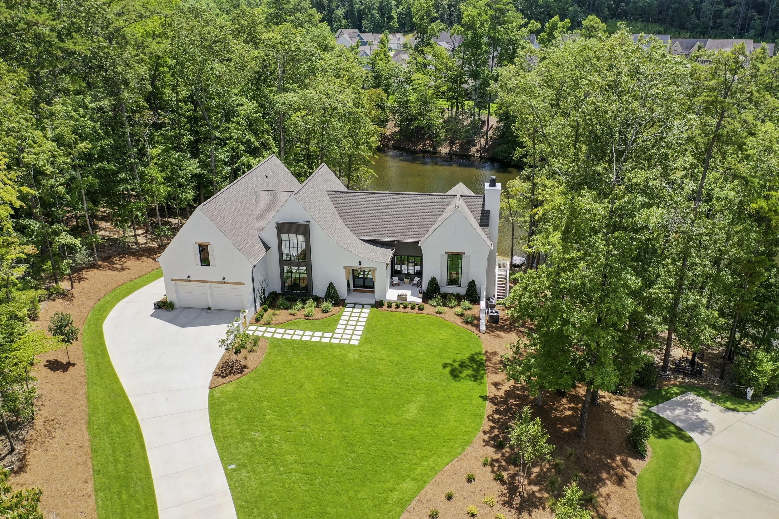 Located on a lakefront property in Hoover, this custom home was built on a challenging lot with a 28-foot elevation change, requiring careful grading and rock retaining walls to create usable front and back yards. Designed for entertaining, the home 
