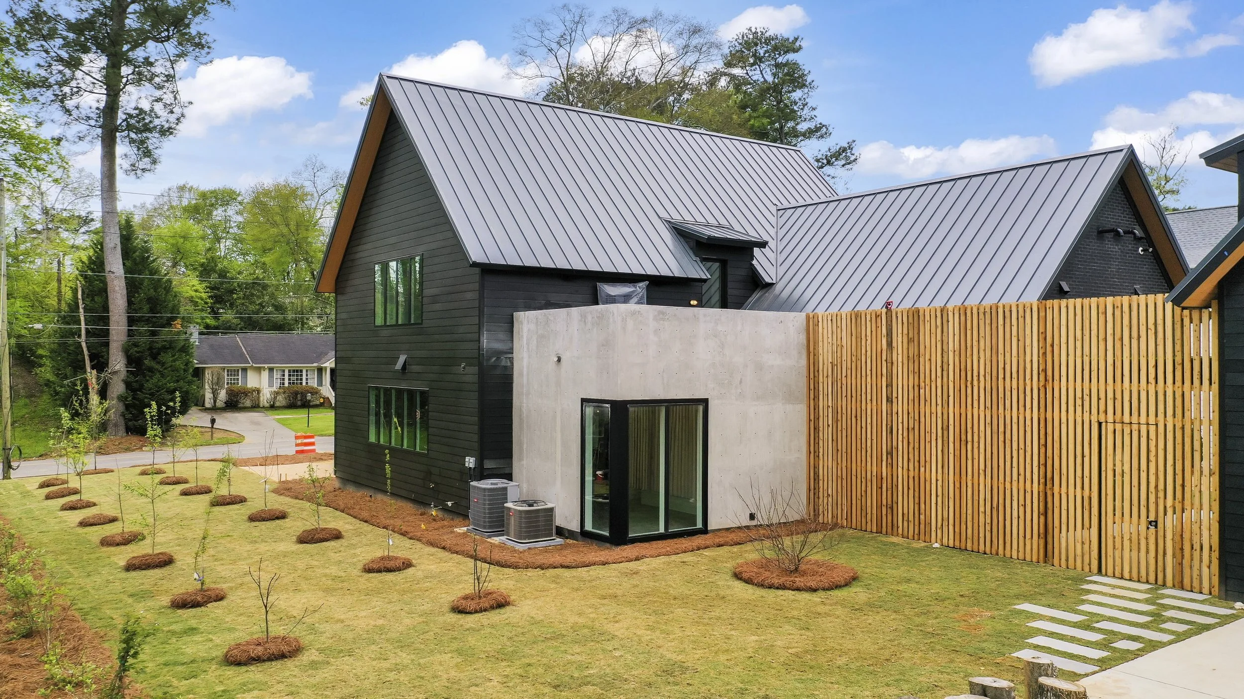 Located in Mountain Brook, this custom home balances modern architecture with the warmth of natural materials, pairing steel and concrete with white oak millwork and polished concrete floors. Hidden doors blend into white oak slat walls, while a cust