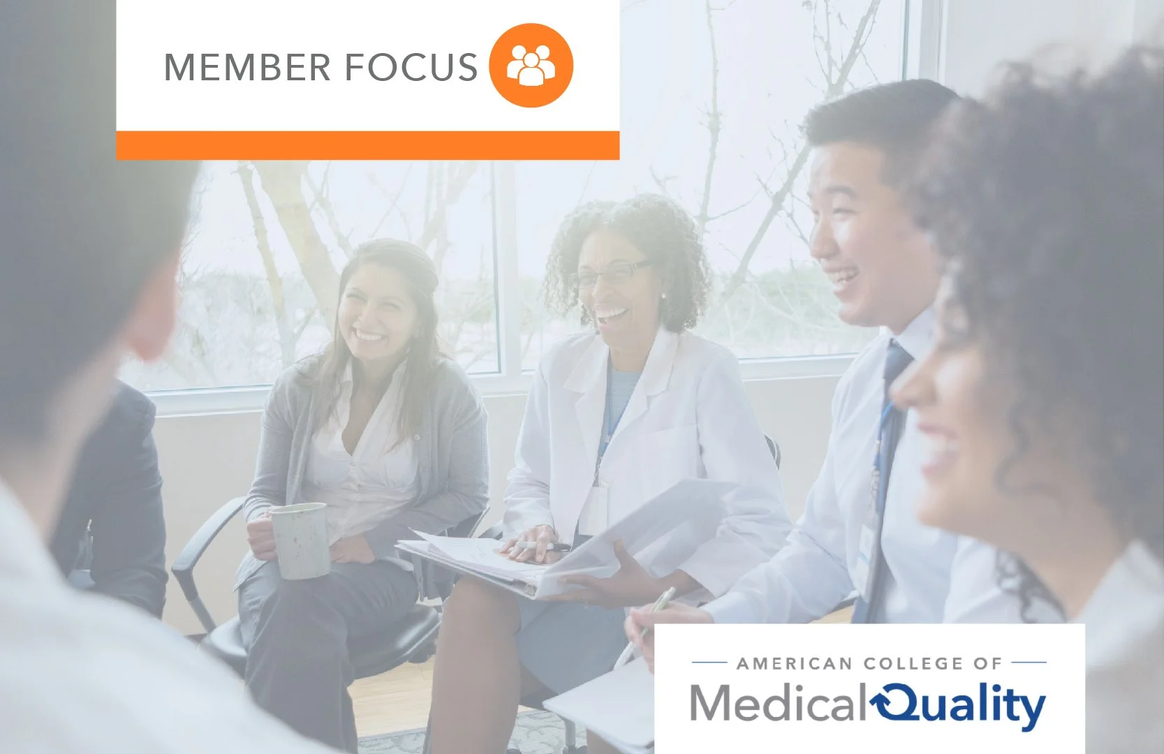 A group of diverse medical professionals and students in a meeting room, smiling and laughing during a discussion.
