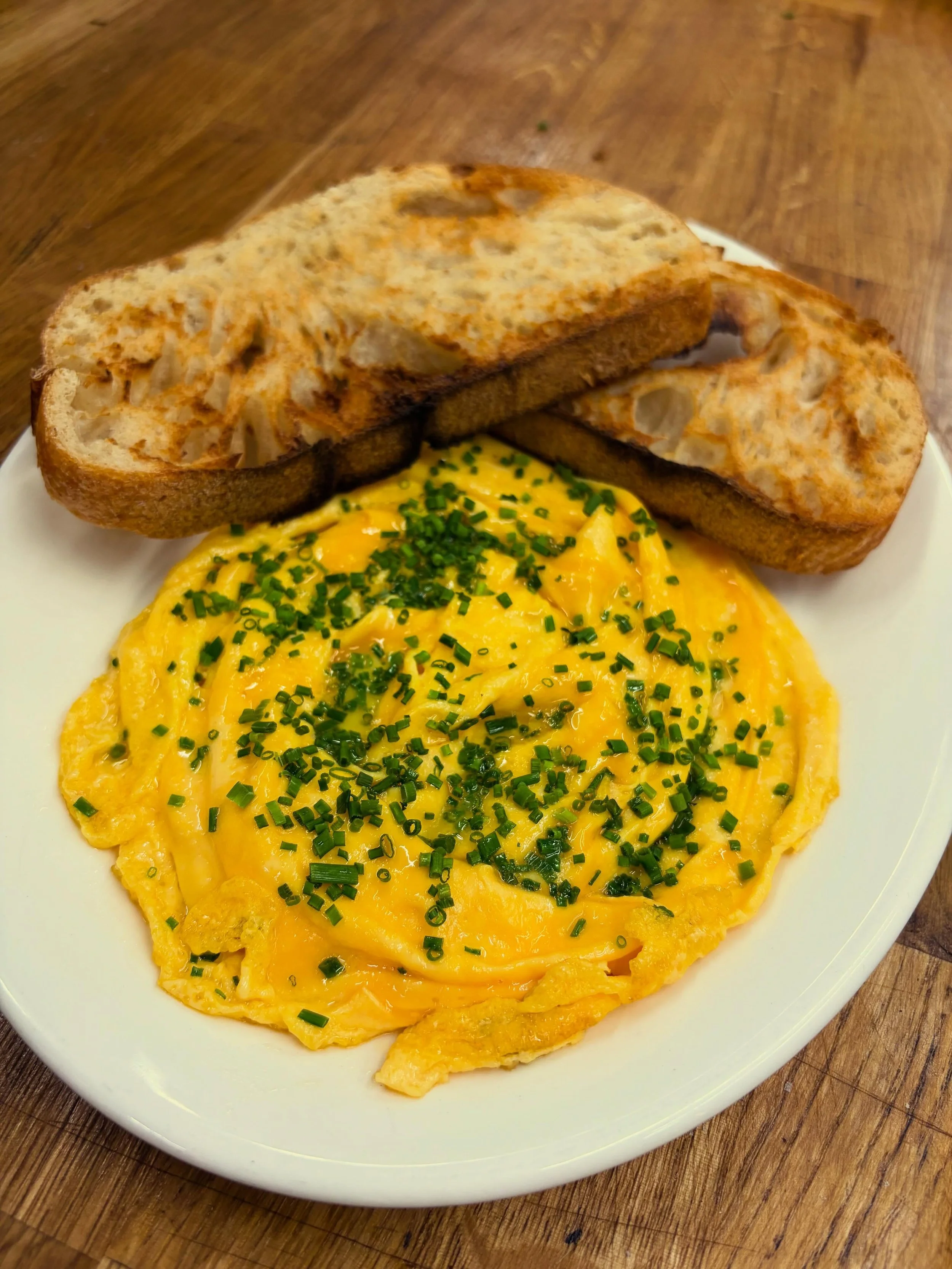 Soft folded eggs, fresh chives, toasted sourdough, and a slow late breakfast kind of morning ✨☕️