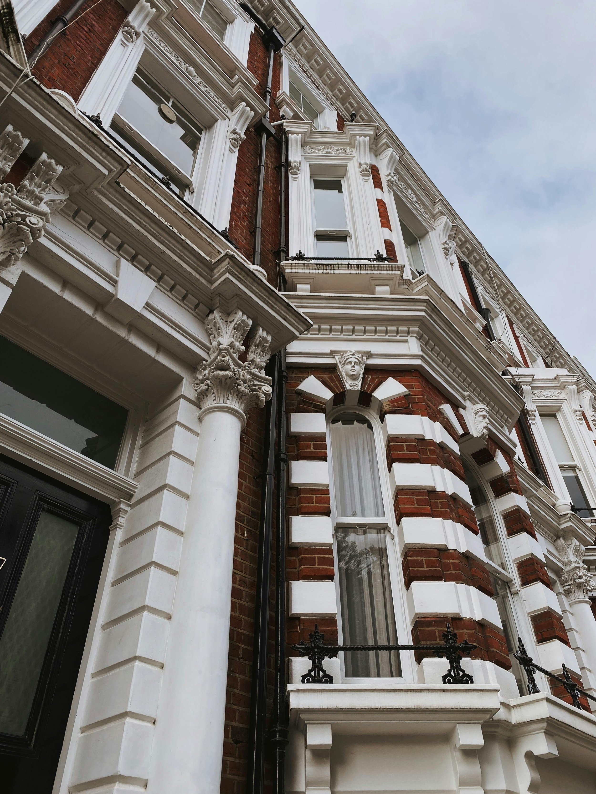 Close-up view of an ornate historic building facade with white decorative trim, columns, and brickwork, used to show different coverages that are offered on a renters insurance policy