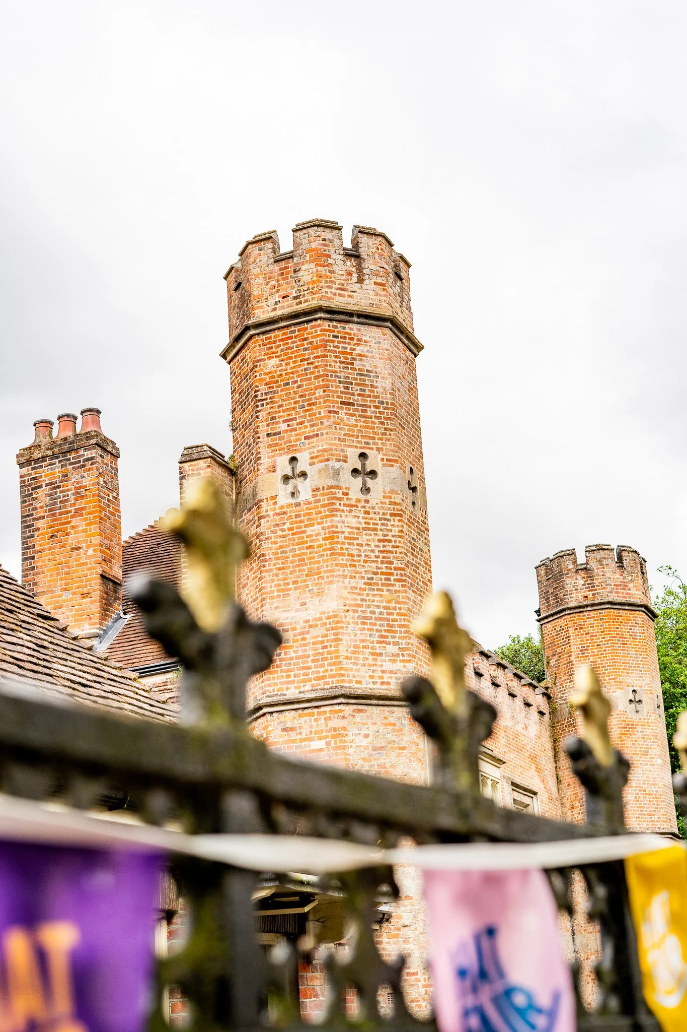 Tudor era castle towers in the background behind an iron fence in Winchester, England on a summer day