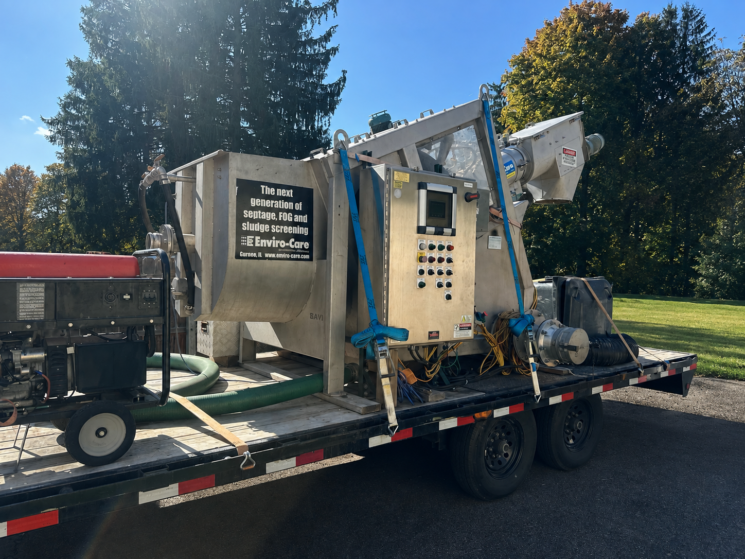 A mobile wastewater screening system mounted on a trailer, featuring machinery and control panels.