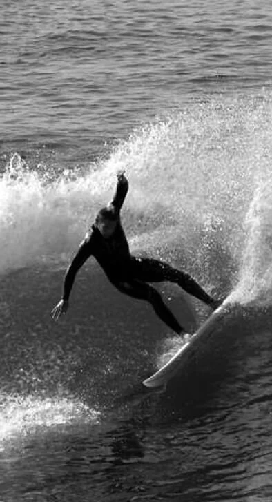 Person surfing on a wave in the ocean. Great surfing in West Cork. Oceansacpes with brillaint surfing. Beaches for surfing near Clonakilty.
