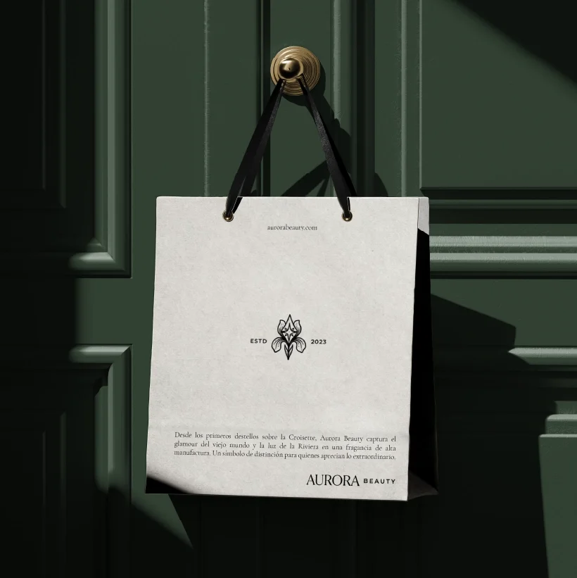 A white paper bag hanging from a hook on a green paneled door.