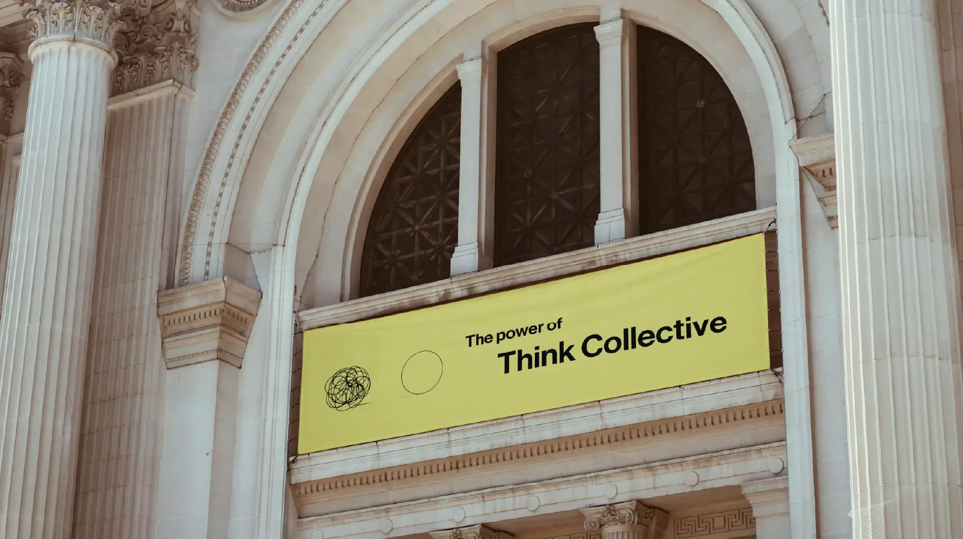 Cartel amarillo en un edificio de columnas clásicas que dice 'El poder del pensamiento colectivo' con diagramas lineales, uno enredado y otro simple, en una estructura arquitrabada decorada.