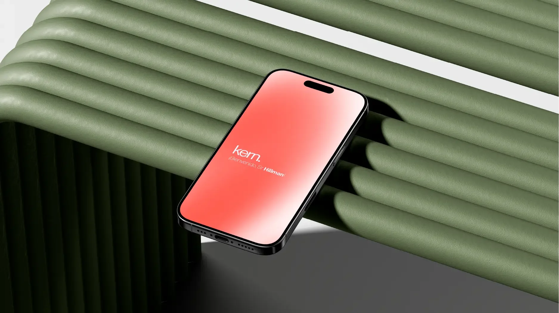 Un teléfono inteligente sobre una superficie verde con aspecto de mimbre, con la pantalla encendida que muestra un mensaje de bienvenida.
