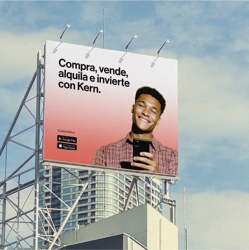 An advertising poster in the city, set against a backdrop of skyscrapers, promoting an app for buying, selling, renting, and investing with Kern, featuring a smiling young man holding a cell phone.