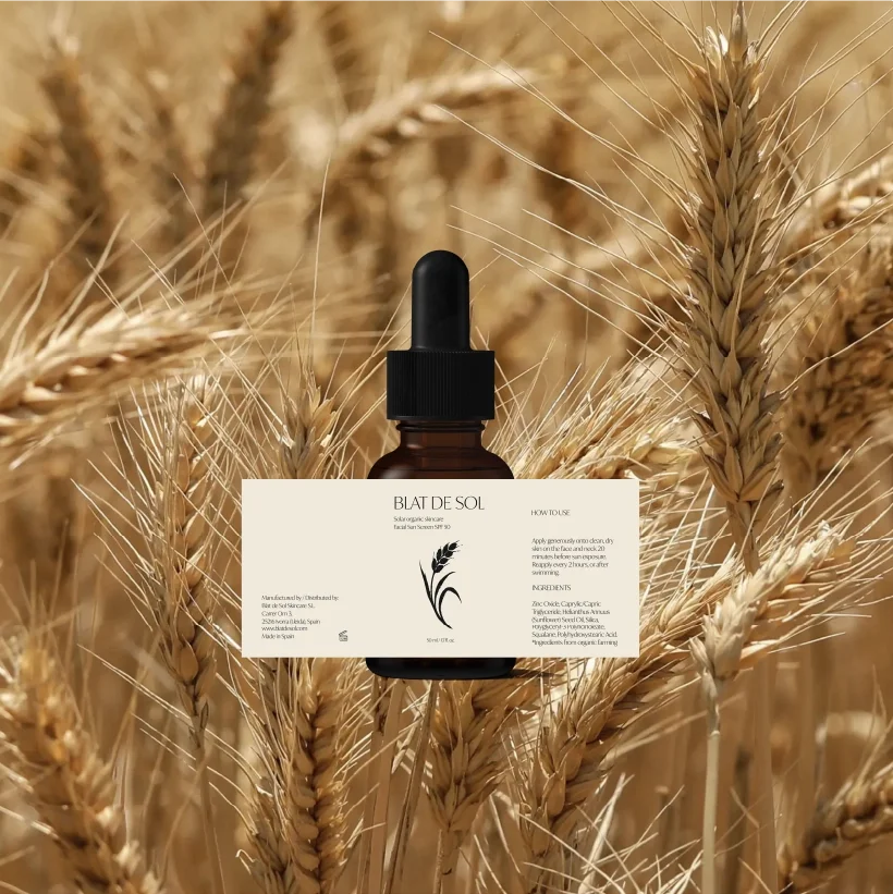 A bottle of skin drops in a field of golden wheat.