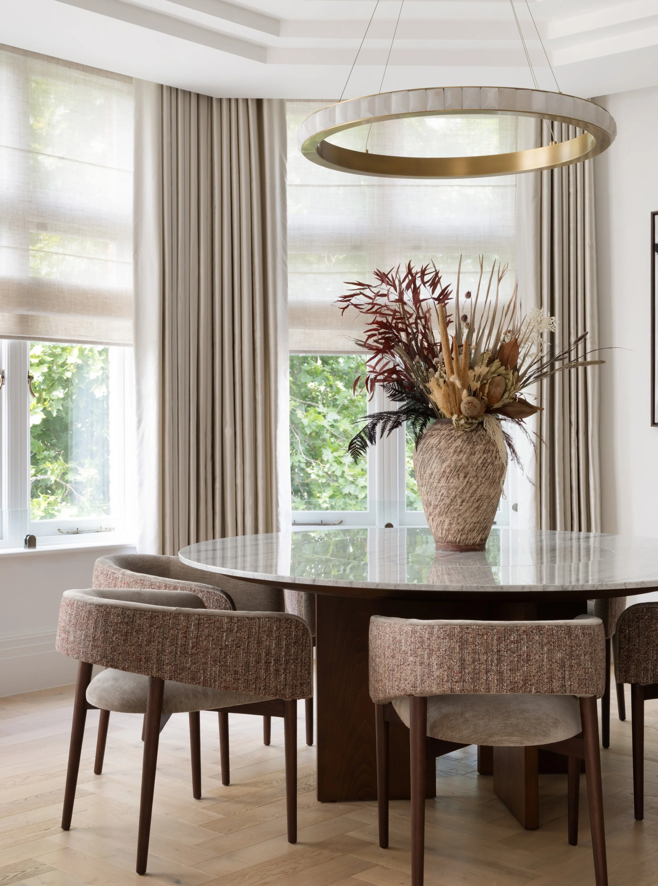 The elegant dining table at The Lucian Home was designed especially for the space, featuring a generous 180cm-diameter Calacatta marble top and a removable Lazy Susan at its centre.

Bespoke dining chairs with contrasting upholstered backs complete t