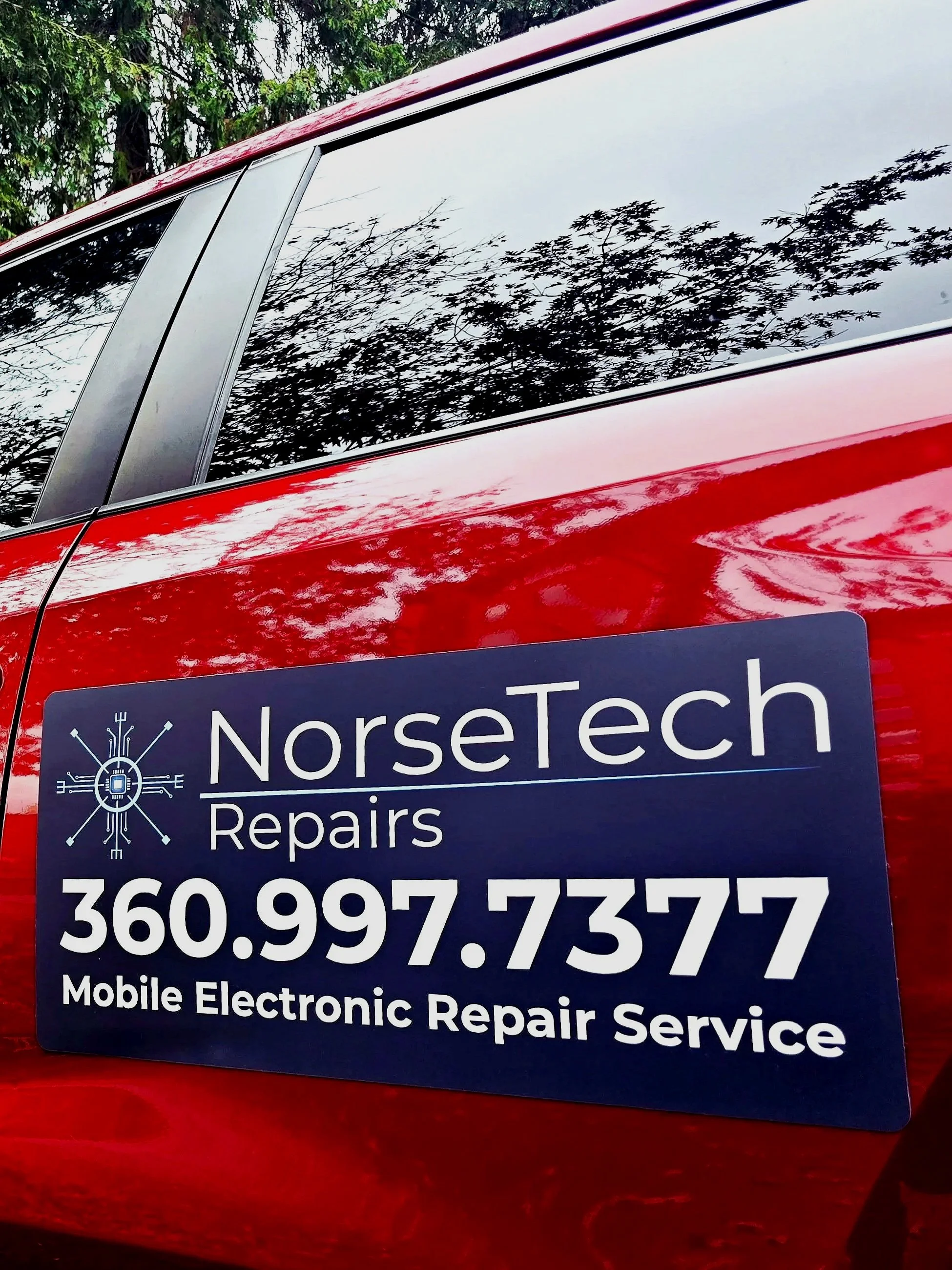 NorseTech Repairs mobile electronic repair service sign displayed on a red vehicle