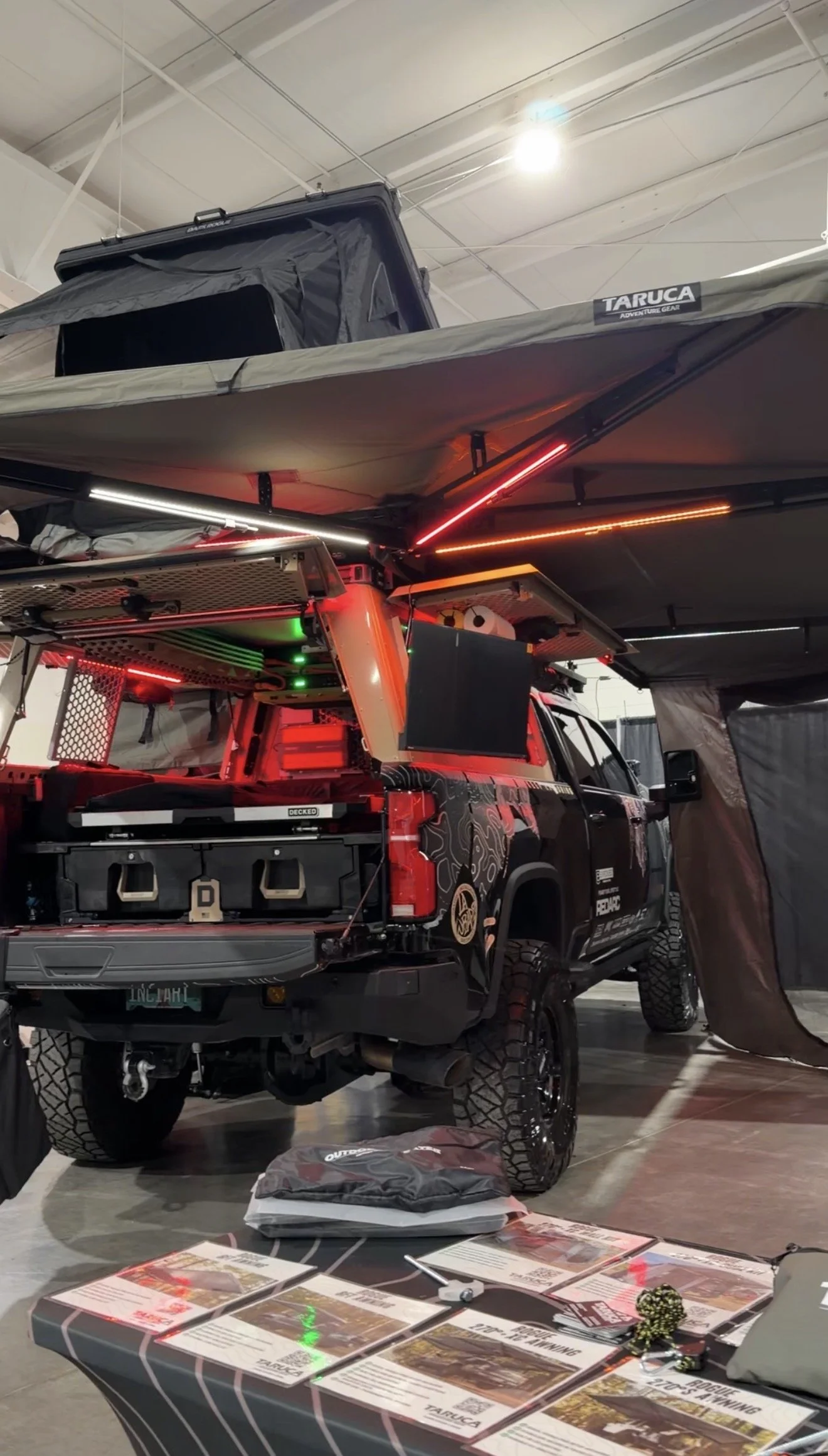 INCIARTE4X4 Chevrolet Silverado 2500 overland build on display with camping gear at an indoor overland expo.