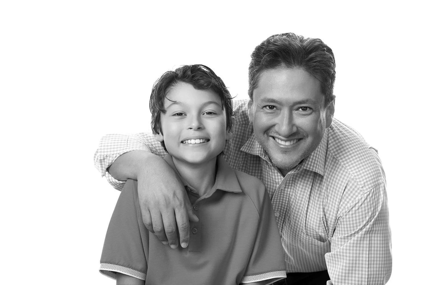 Black and white photo of a man and a boy smiling, with the man's arm around the boy's shoulder.