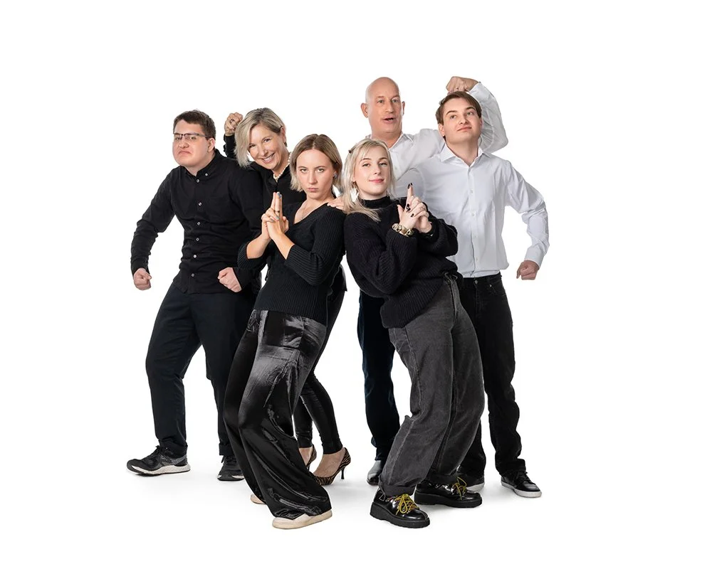 Group of six diverse people posing confidently against a white background.
