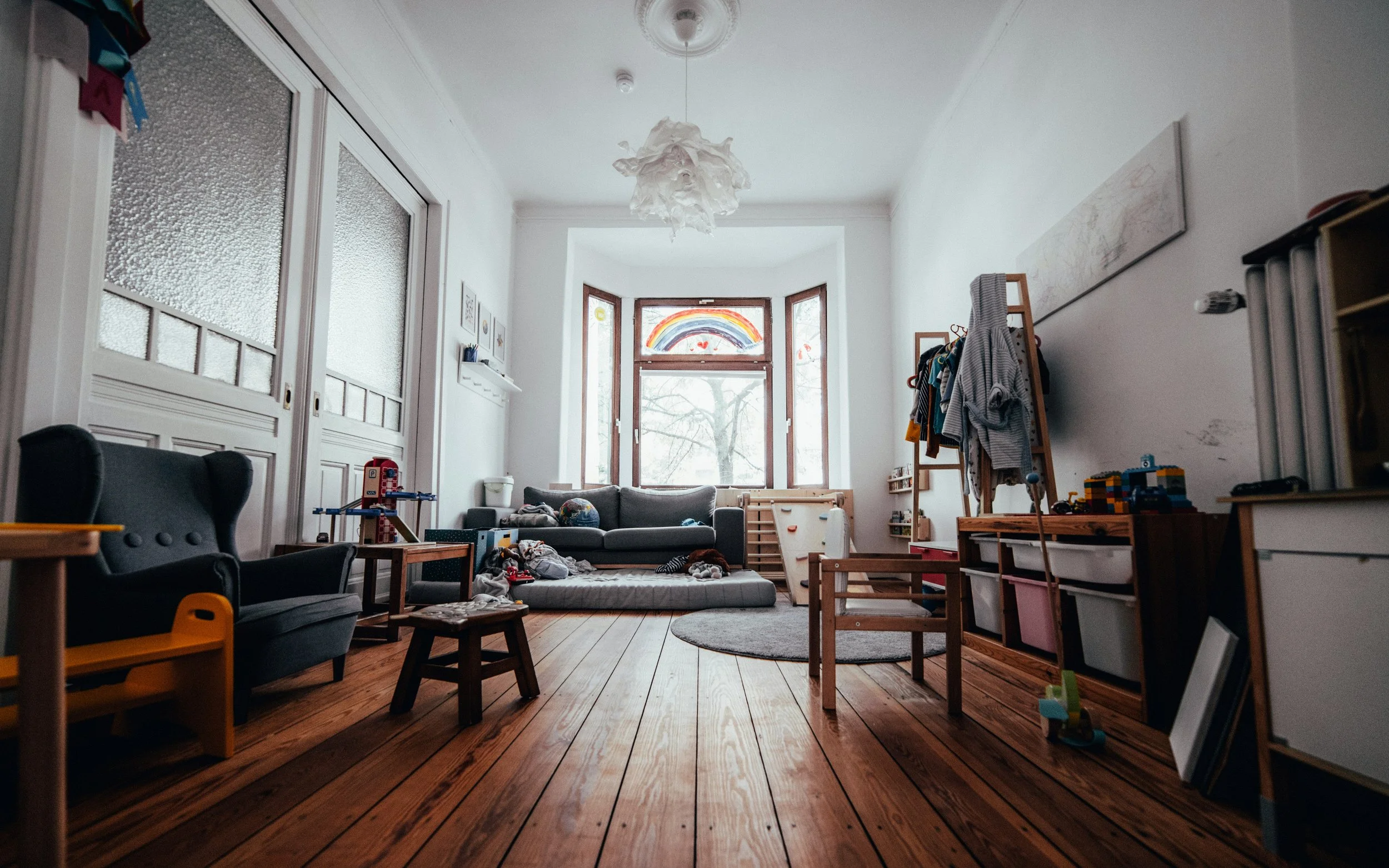 Living room with wooden floors and bay windows, with light coming in the windows