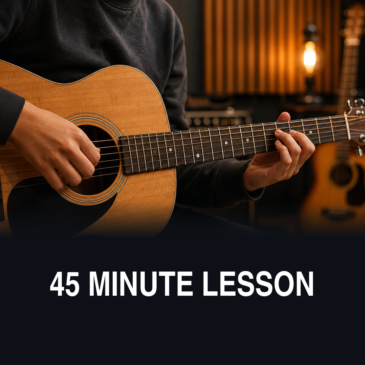 Person playing an acoustic guitar in a recording studio with warm lighting.