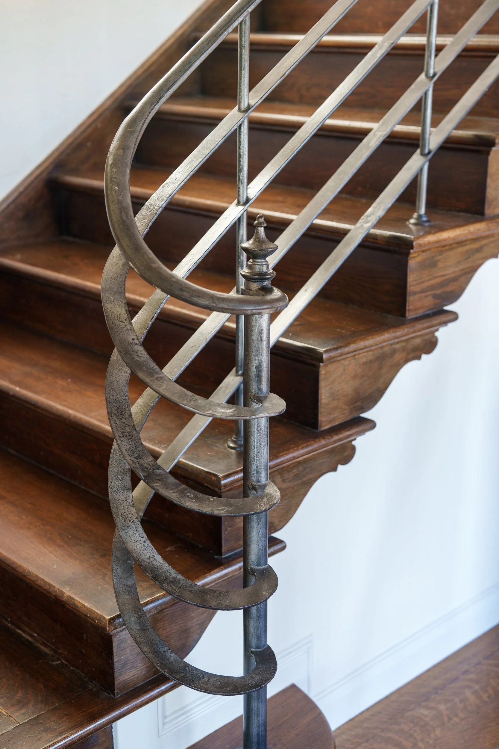 Close-up of a wooden staircase with metal railing.