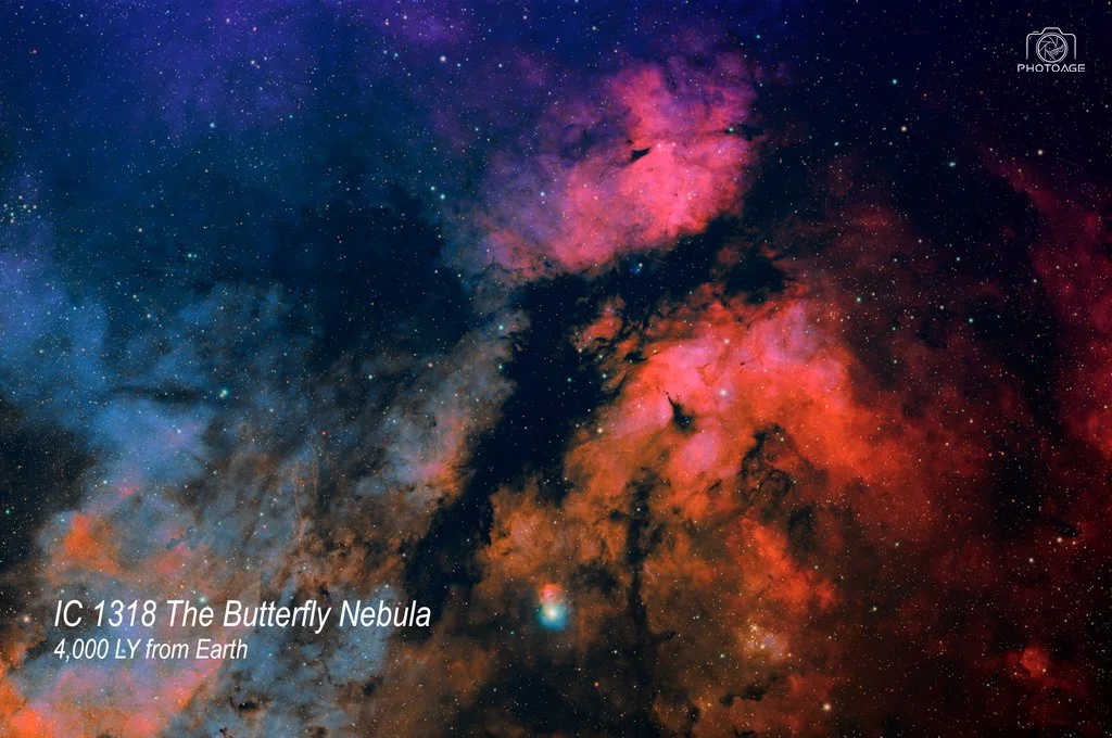 An image of the Butterfly Nebula in space with colorful pink, red, purple, and blue clouds of gas and dust, along with numerous stars, with text indicating it's the IC 1318 The Butterfly Nebula, 4,000 light-years from Earth.