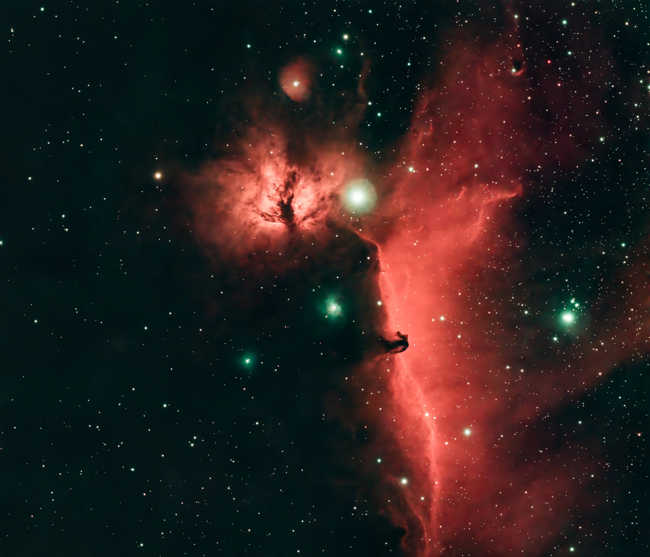 Deep space image of a nebula with glowing pink and red gas clouds, surrounded by numerous stars of various sizes and brightness.