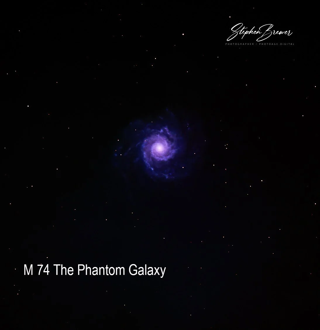 A photograph of the M74 galaxy, also known as the Phantom Galaxy, showing a bright spiral with surrounding stars against black space background. The photo is credited to Stephen Brewer.