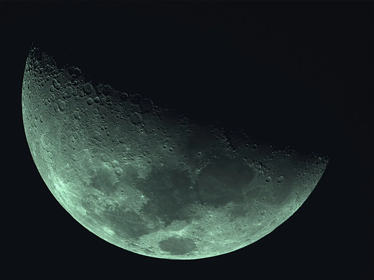 Close-up of the moon showing craters and surface details with a dark background.