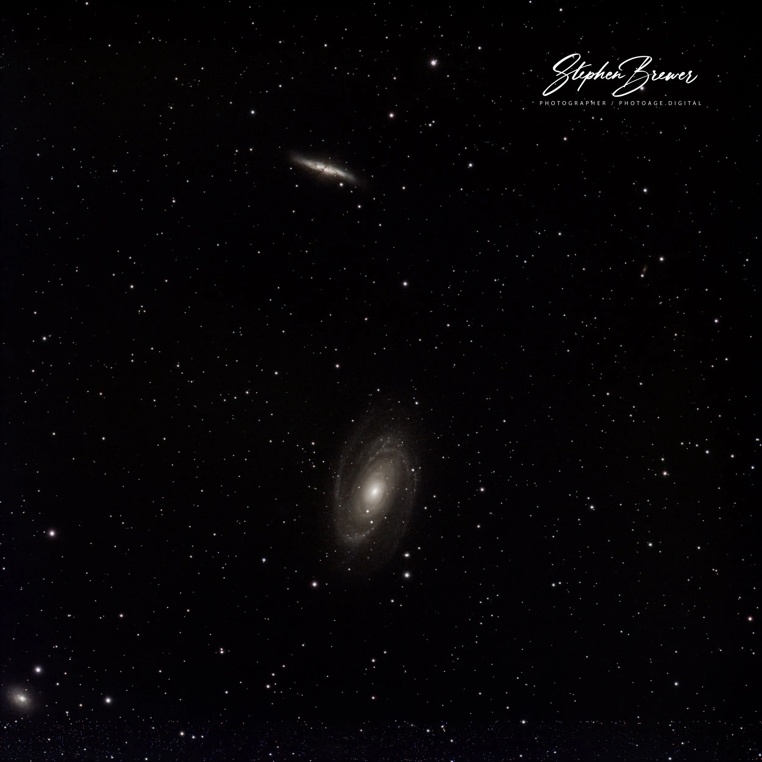 Deep space photograph showing numerous stars, galaxies, and celestial objects with a watermark of a photographer's signature in the upper right corner.
