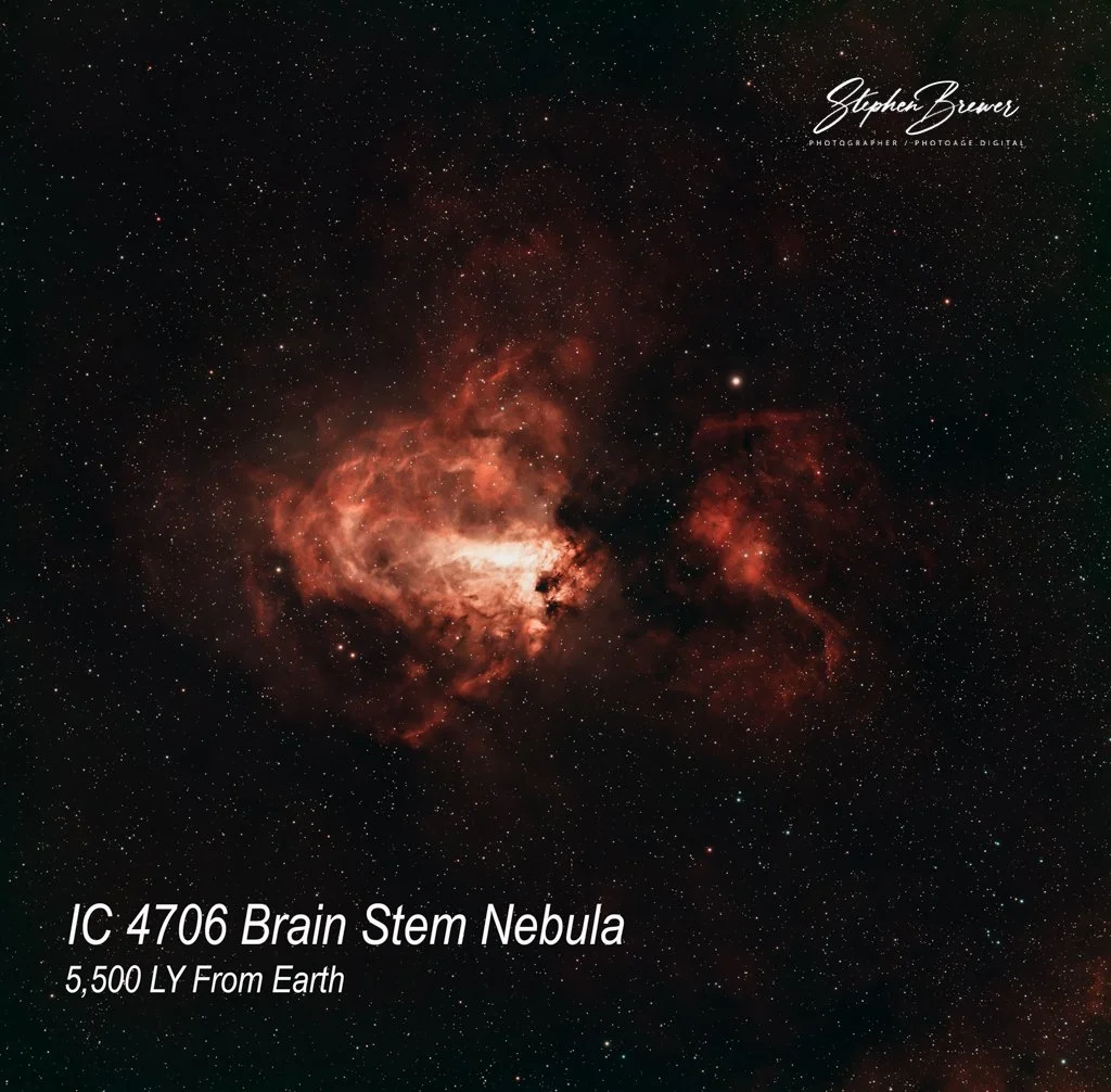 An image of the IC 4706 Brain Stem Nebula, a red and orange glow in outer space filled with stars, with text indicating it is 5,500 light years from Earth and credit to photographer Stephen Brewer.