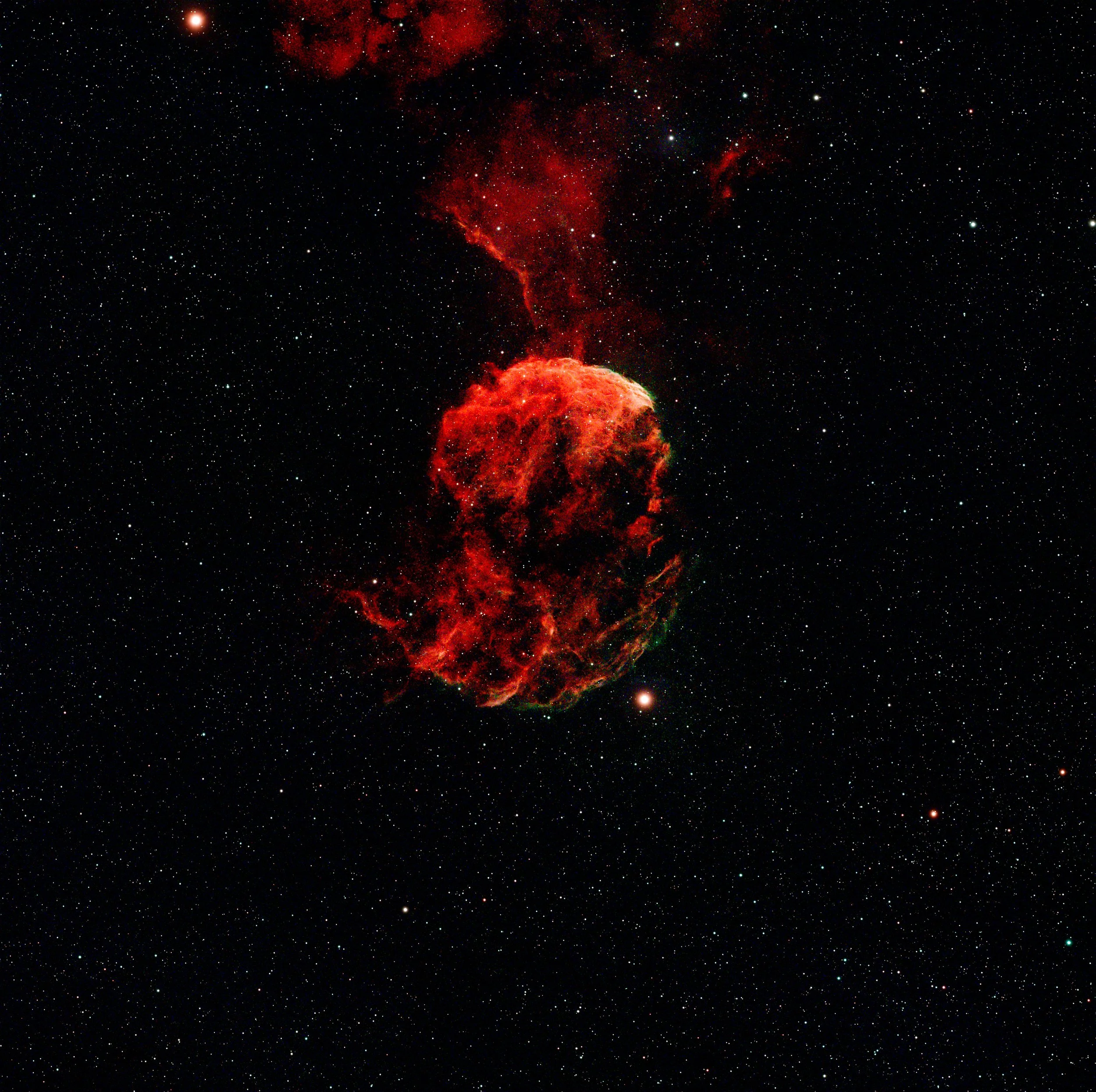 Image of a vibrant nebula in outer space with countless stars and a large glowing red cloud formation.