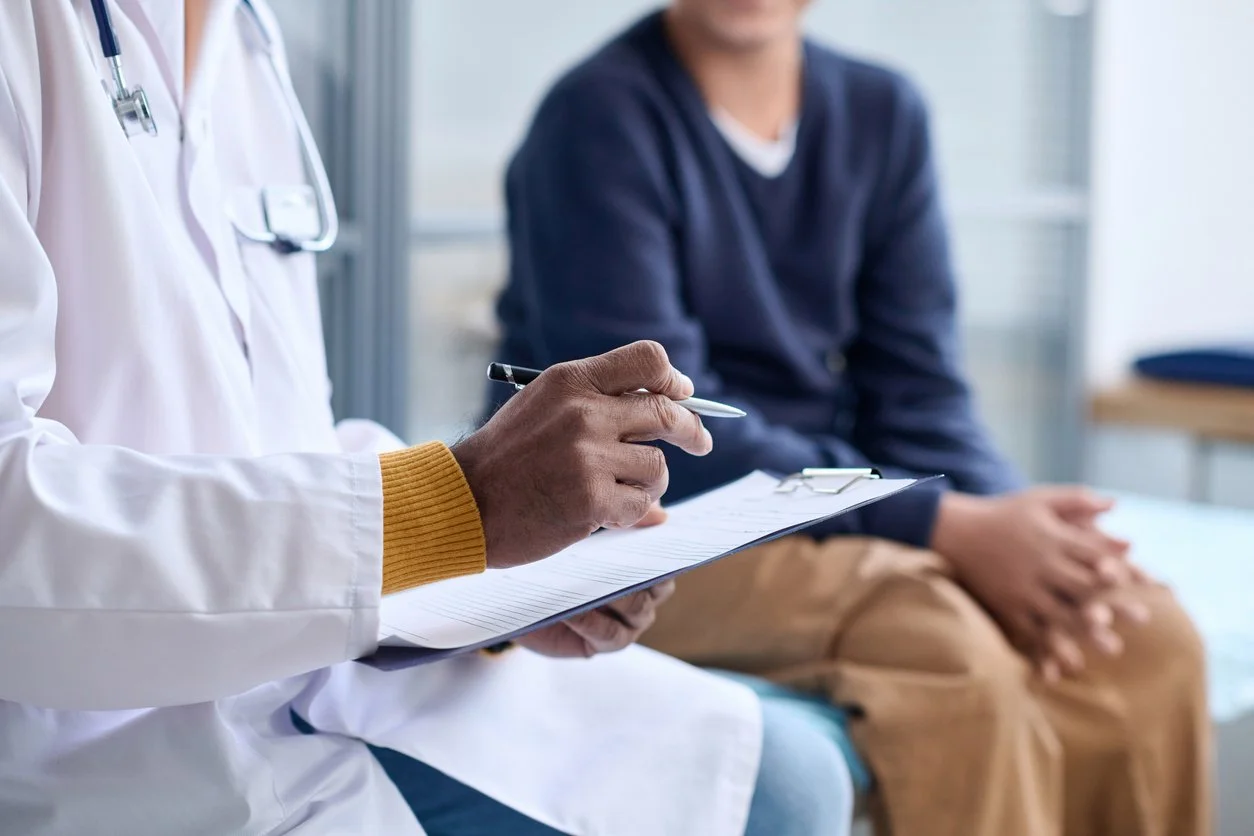 A clinician taking notes during a patient assessment