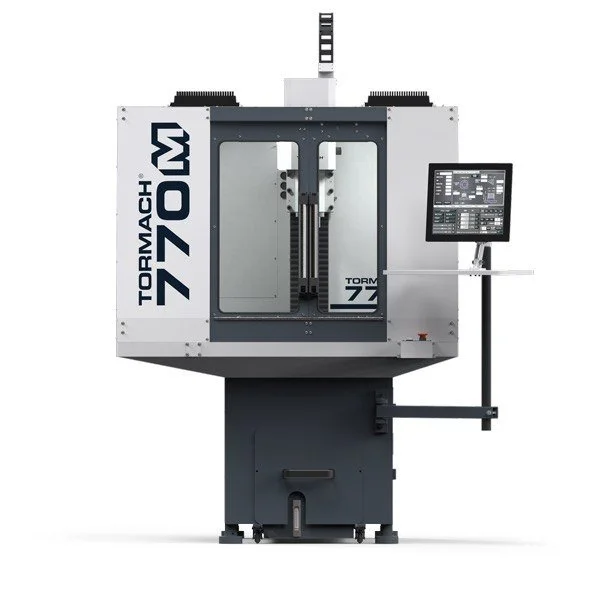 A Tormach 1100M CNC milling machine with a control screen on the right side and enclosed workspace.