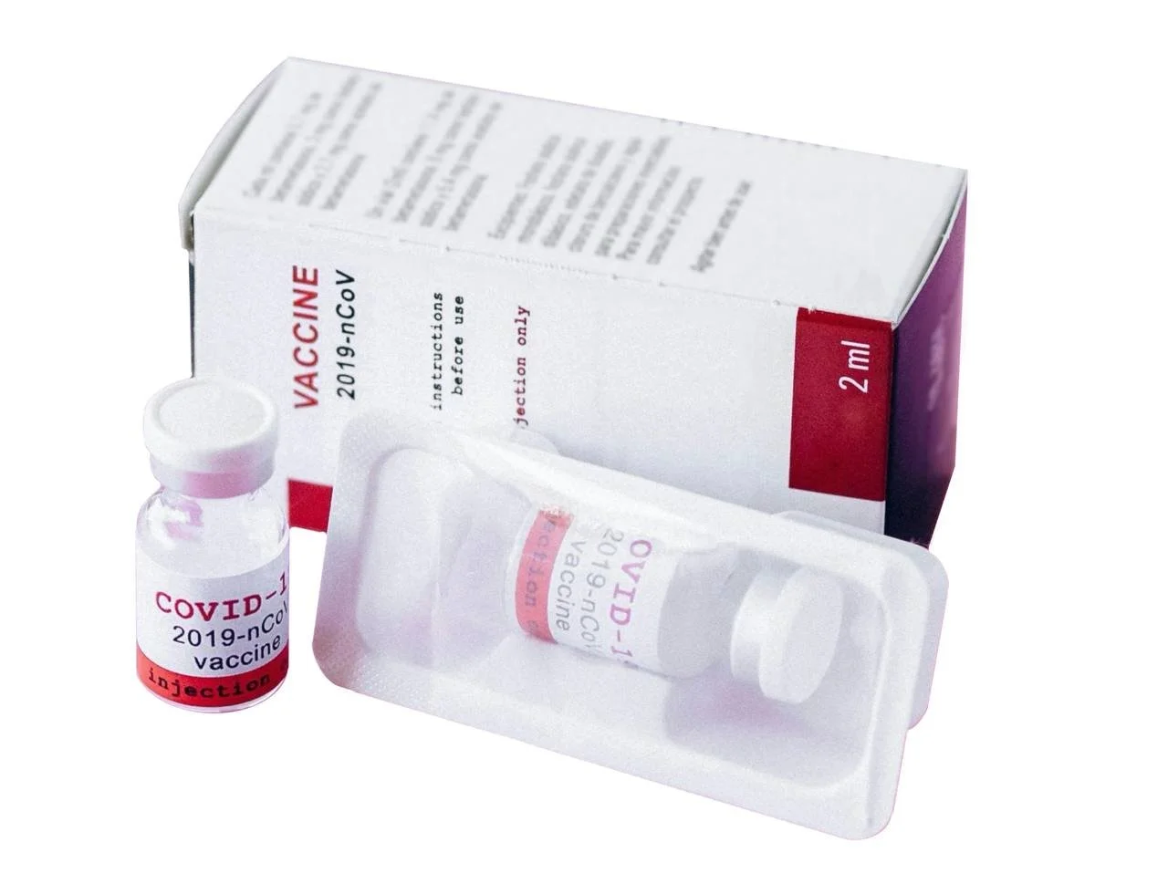 A 2 ml vial of COVID-19 vaccine next to a box and a clear plastic tray with the vial inside. The labels on the vial and box indicate COVID-19 vaccine with injection warning, and the box mentions 2019-nCoV and last instructions before use.