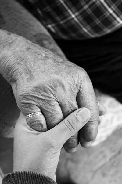 Closeup of small hand holding a wrinkled hand