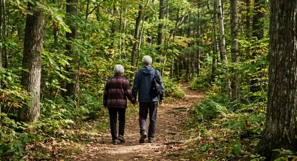 Couple holding hands walking along a path in a forest