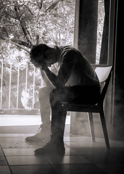 Man sitting by window in dark room